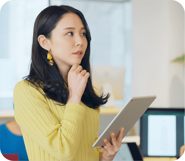 タブレットを手に悩む女性